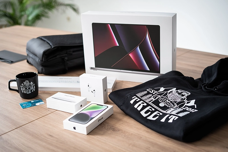 Bild vom Willkommenspaket für neue Mitarbeiter mit Hardware und Kleidung